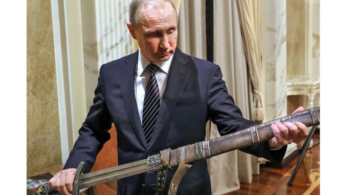 Russian President Vladimir Putin examines a sword during a meeting Friday with teh crew of the historical action film “Viking.”