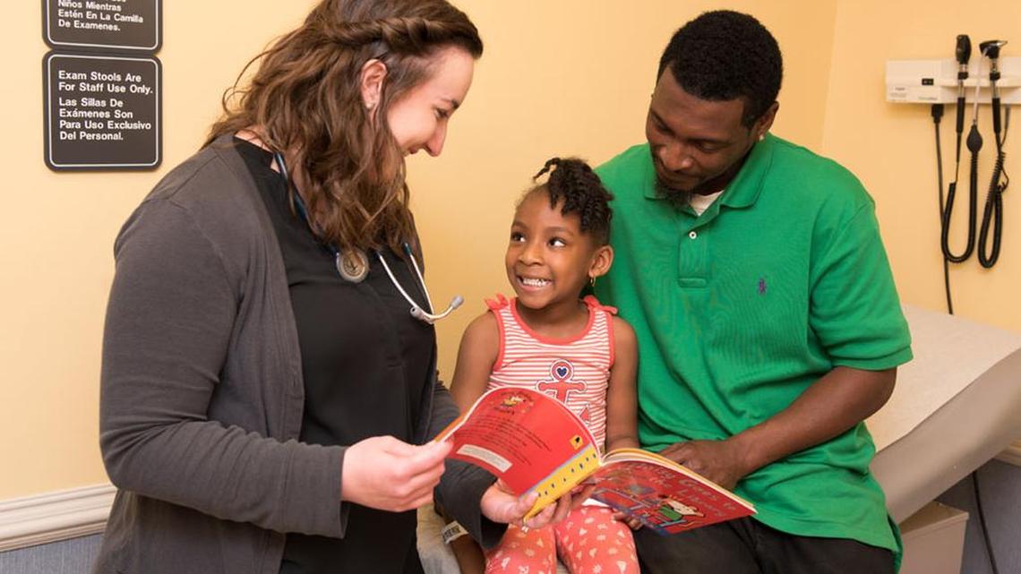 Dr. Kelsy McDill shares a book with her patient at Palmetto Health Children’s Hospital Outpatient Center, as part of the Reach Out and Read effort.