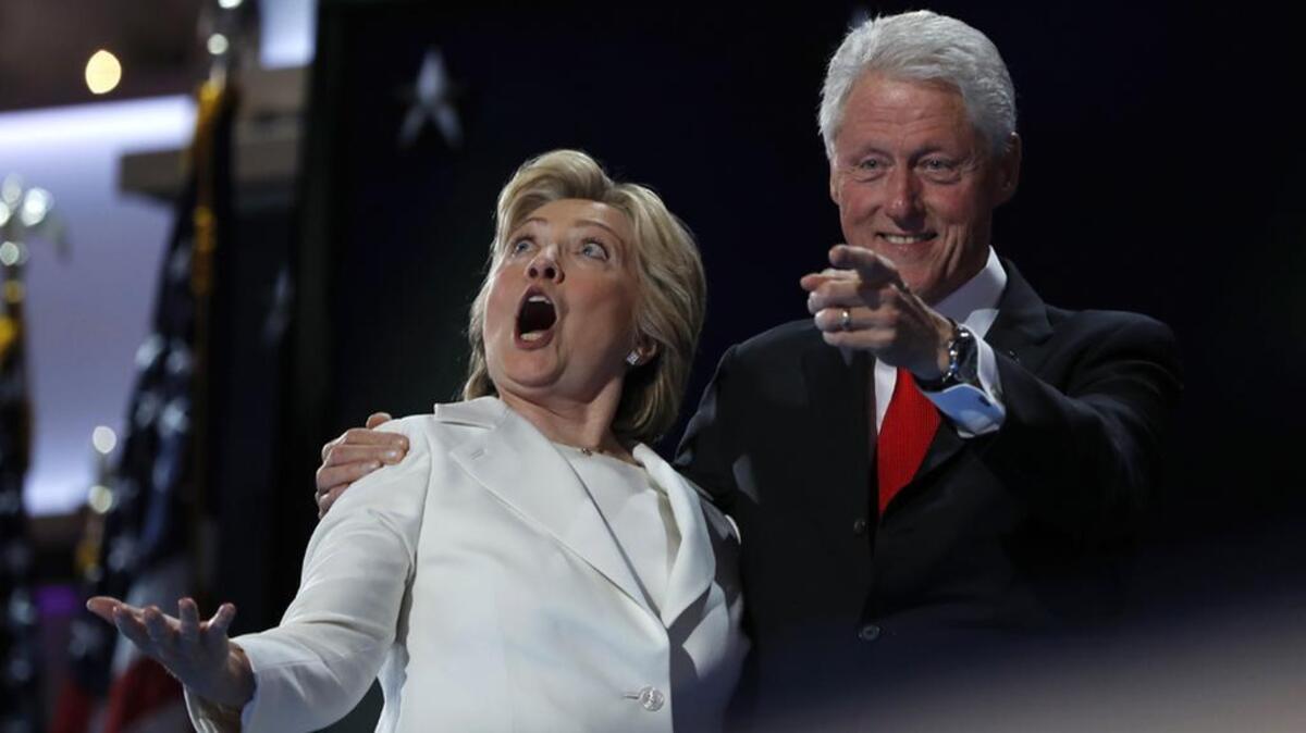 Democrat Hillary Clinton and Former President Bill Clinton react as balloons fall during the final day of the Democratic National Convention.