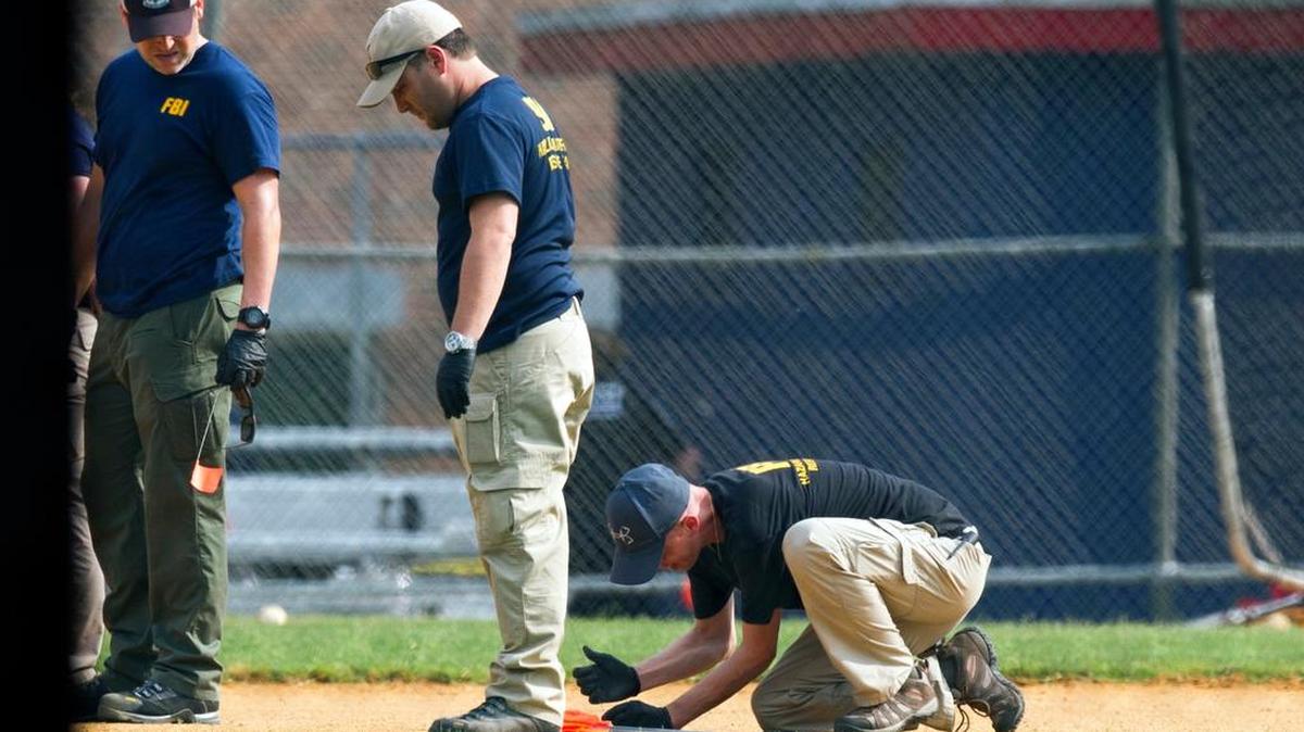 A FBI Evidence Response Team marks evidence on the ball field that was the scene of a multiple shooting in Alexandria, Va., on Wednesday.