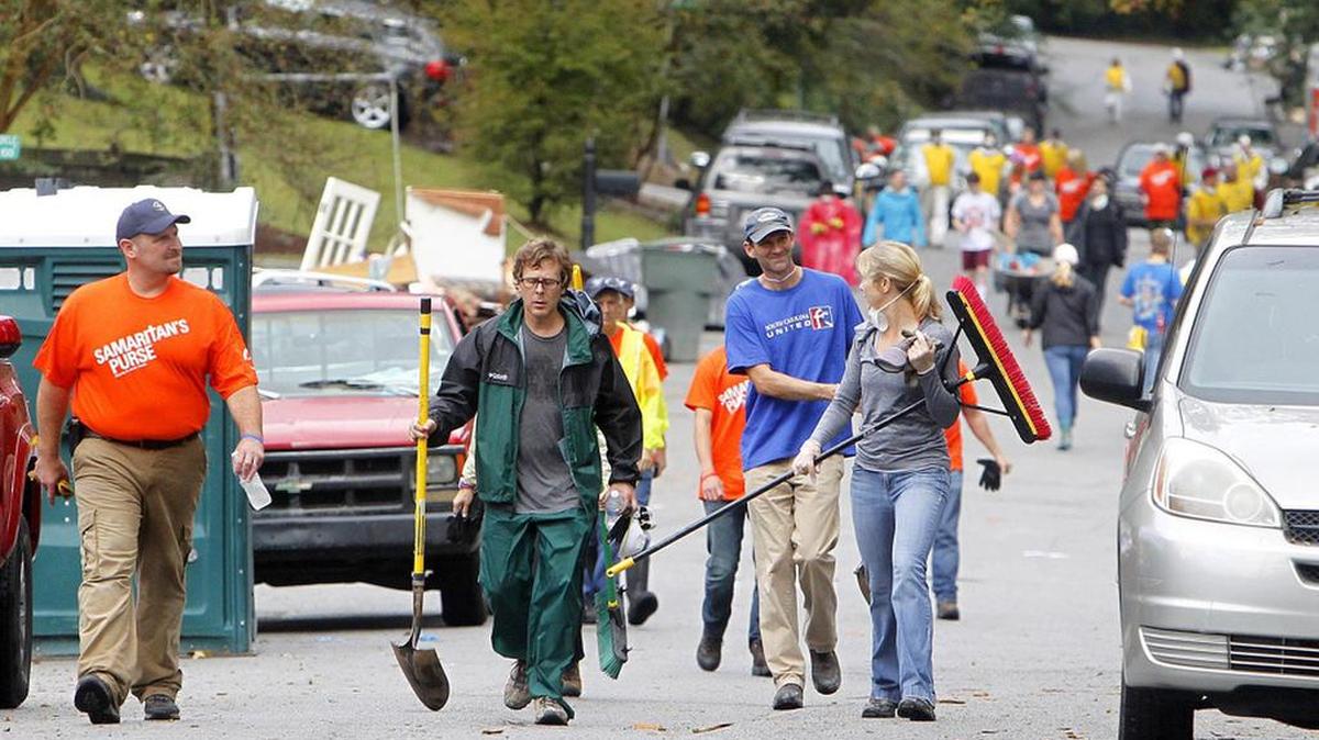 Volunteers head down Glenhaven Drive a week after the floods to help clean up damaged homes.