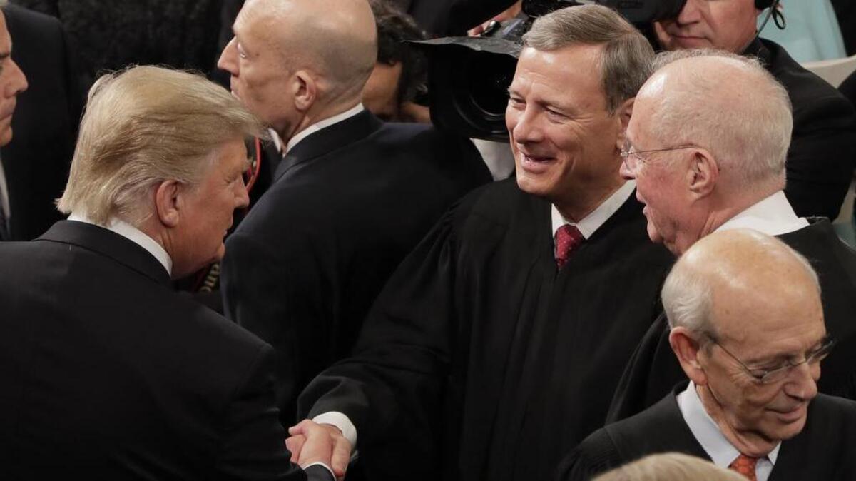 Chief Justice John Roberts shakes hands following President Donald Trump’s address to a joint session of Congress. Many saw the chief justice’s commencement address as a slap at the president.