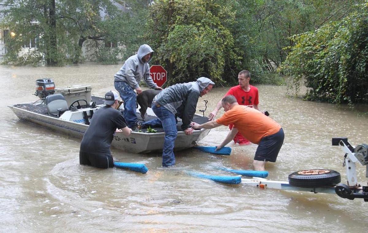 In this file photo, volunteers John Wienges, Bruce Fleming, Steven Smith and Will Lenski help rescue Craig Smith and his dog, Hokey, from their flooded home near Gills Creek during the historic 2015 flooding in Richland County.