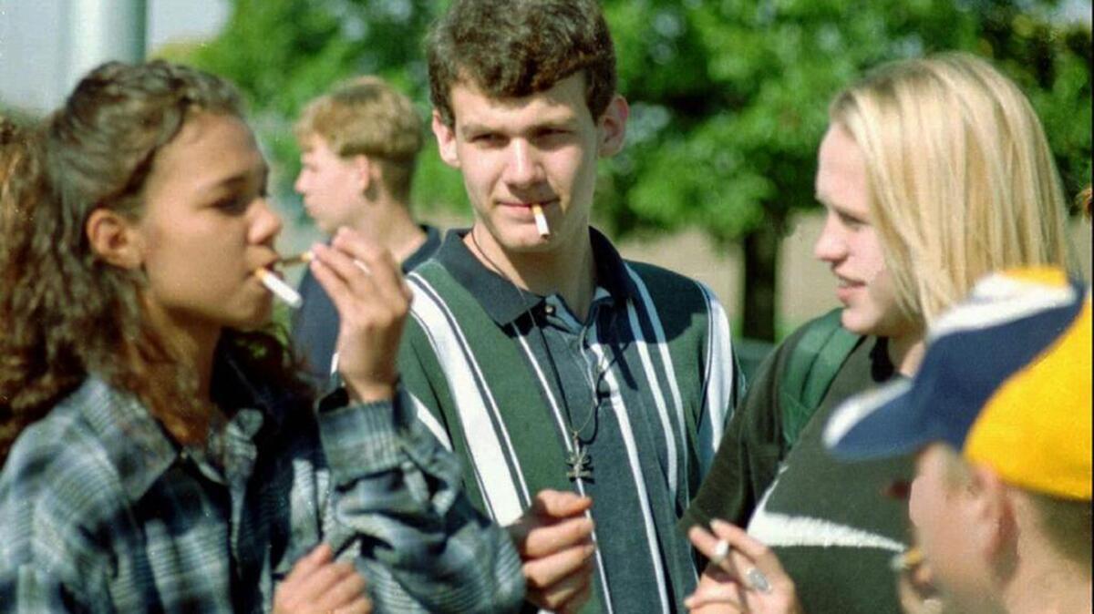 Students take a smoke break at the smoking corner near their high school.