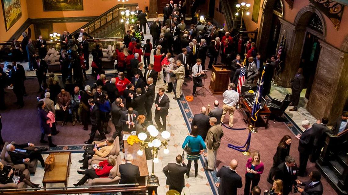 A crowd of legislators and lobbyists packs the lobby between the House and Senate.