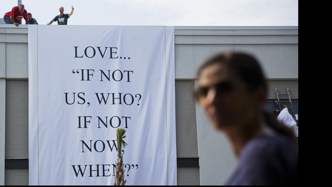 
A worker gestures to a colleague as they hang a banner from a local business near the Emanuel AME Church in Charleston.
