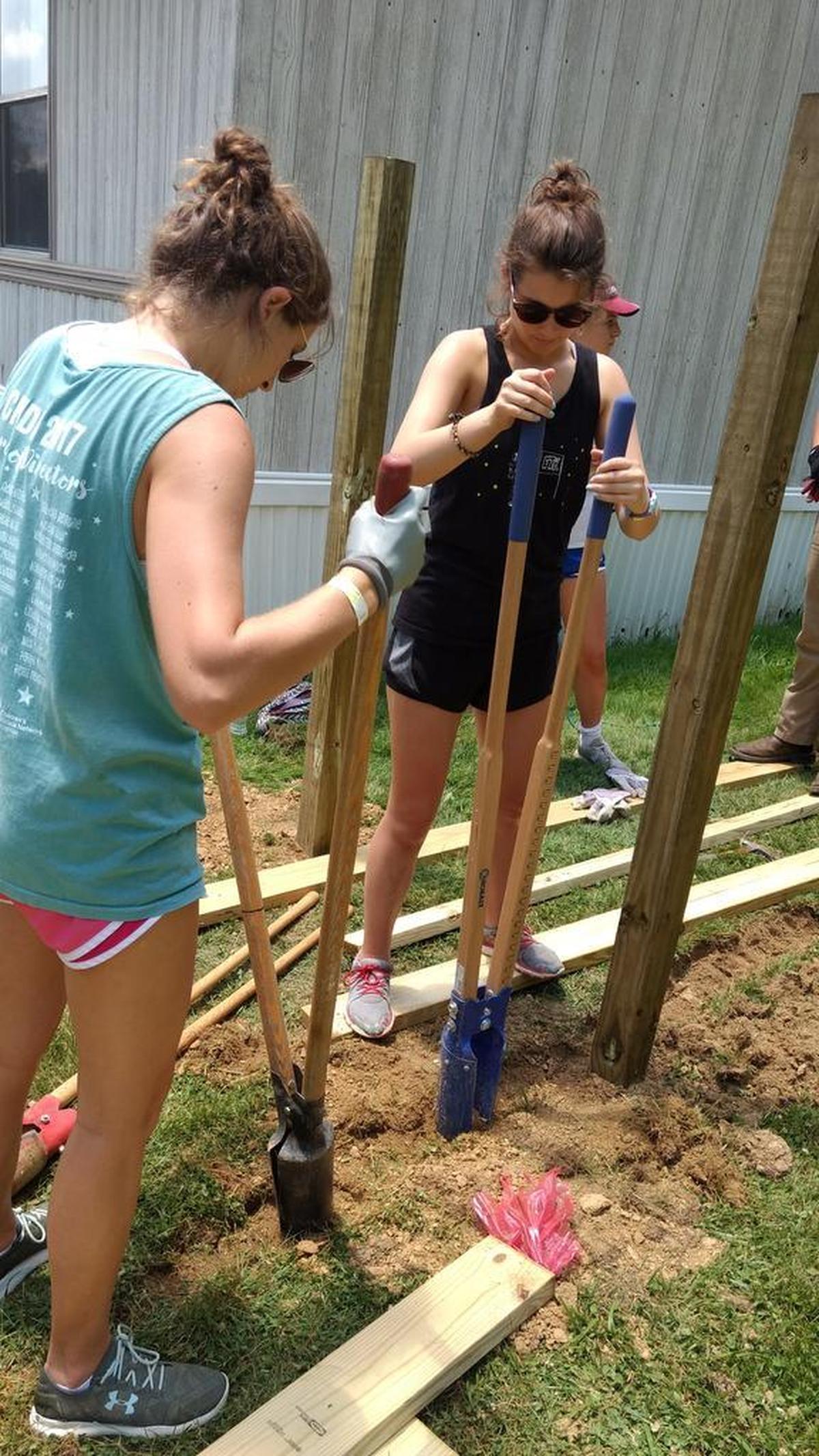 Step 2 in building a ramp: digging post holes. (Step 1 is measuring.)