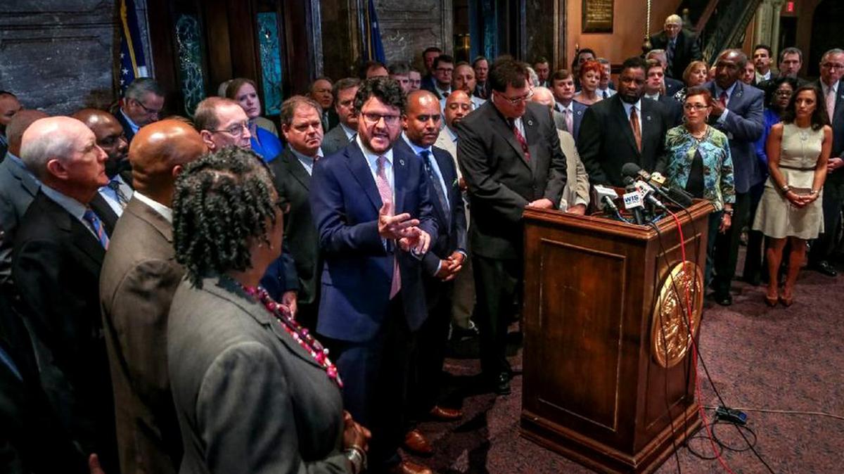 SC House Speaker Jay Lucas, standing back from the lectern, listens as Majority Leader Gary Simrill speaks at a news conference of House Republicans and Democrats urging the Senat to approve their gas-tax bill to fund road improvements.