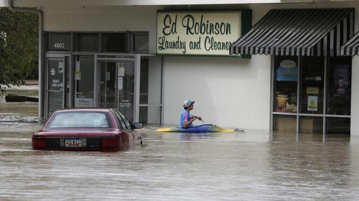 
Jordan Bennett of Rock Hill paddles up to a flooded store in Columbia on Sunday. The rainstorm that drenched the East Coast cut power to thousands in South Carolina, forced hundreds of water rescues and closed many roads because of floodwaters.

