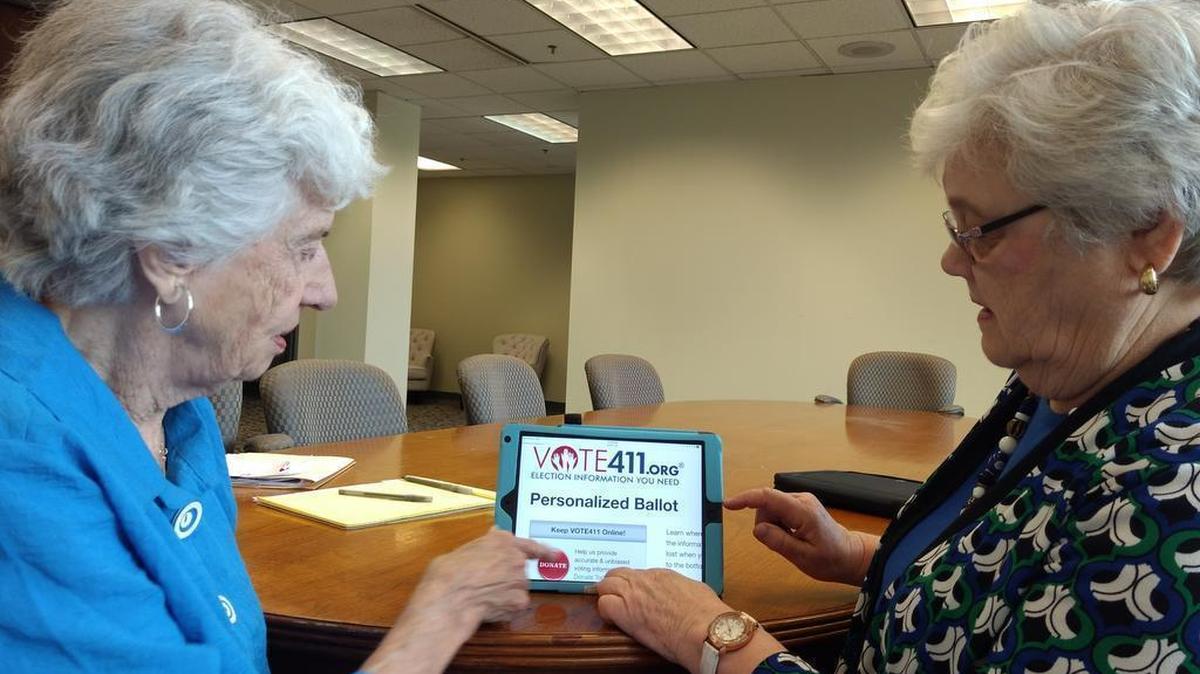 Keller Barron, left, and Janelle Rivers demonstrate the League of Women Voters’ Vote411 website, which provides voters information about the candidates they’ll be able to choose from.