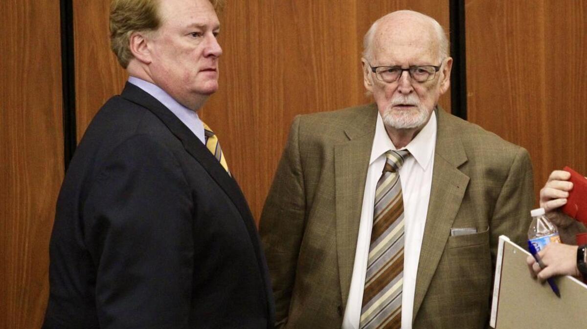 Indicted state Rep Rick Quinn, left, and his father, Richard Quinn Sr., talk during a break in Tuesday’s hearing.