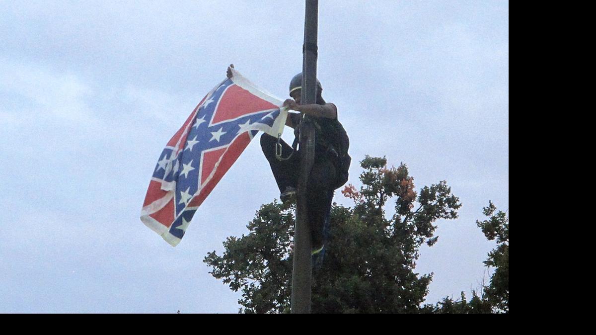 
Bree Newsome of North Carolina tears down the Confederate battle flag at a Confederate monument at the SC State House on Saturday.

