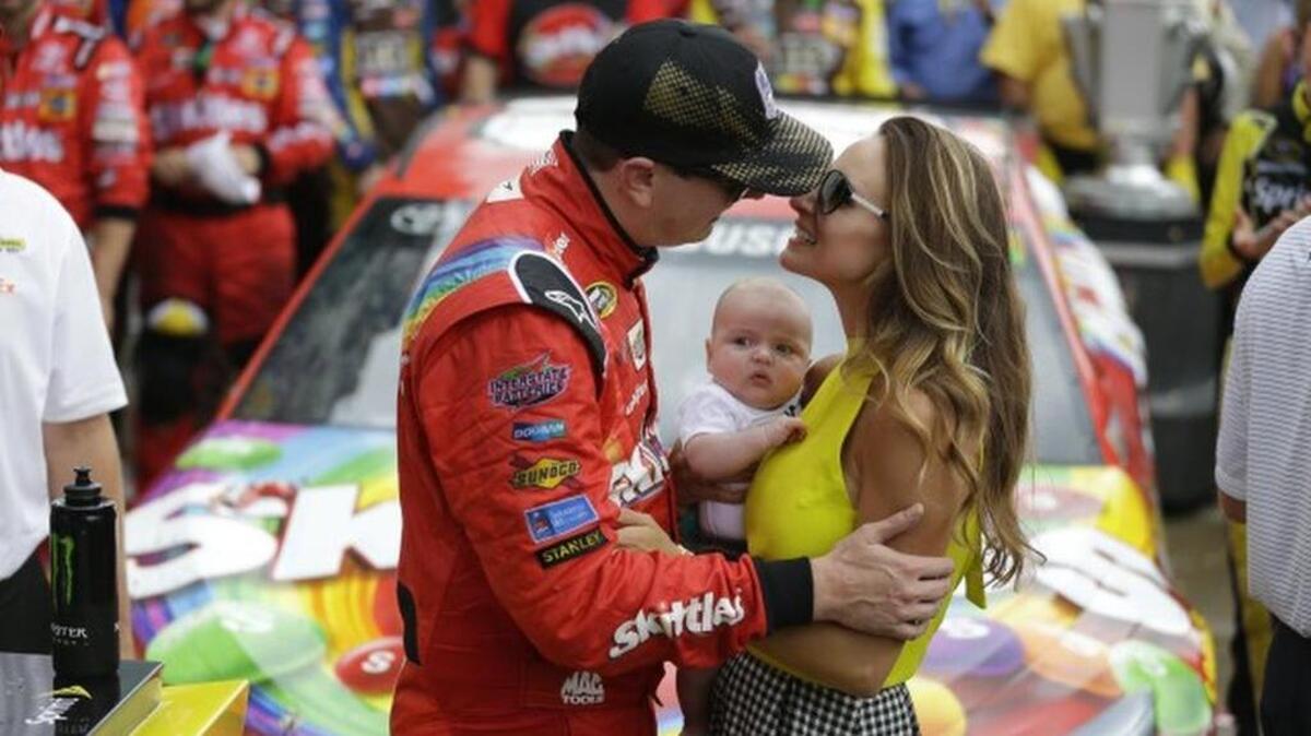 
Sprint Cup Series driver Kyle Busch (18) kisses his wife Samantha as his son Brexton looks on as he celebrates after winning the NASCAR Brickyard 400.
