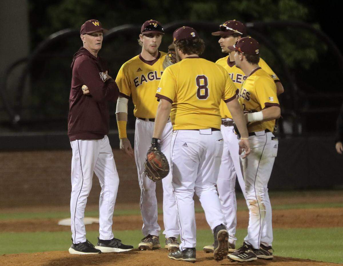 Winthrop baseball head coach Tom Riginos talks with the team at the pitcher’s mound.