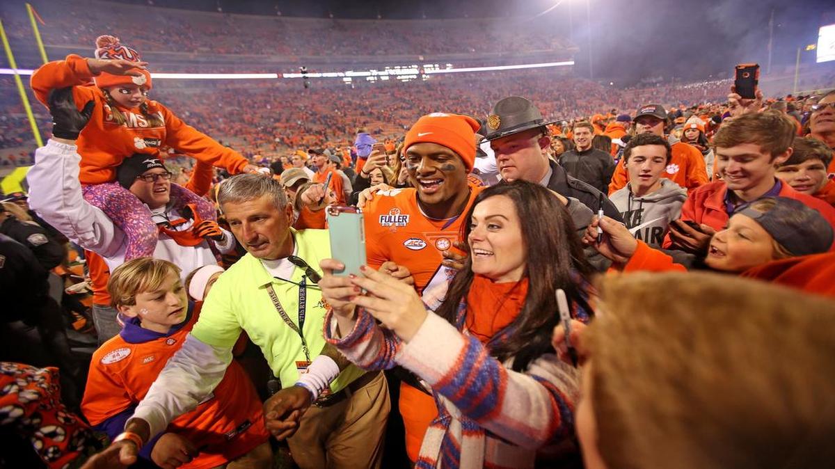 Clemson Tigers quarterback Deshaun Watson (4) takes selfies with fans as he celebrates the win over South Carolina.
