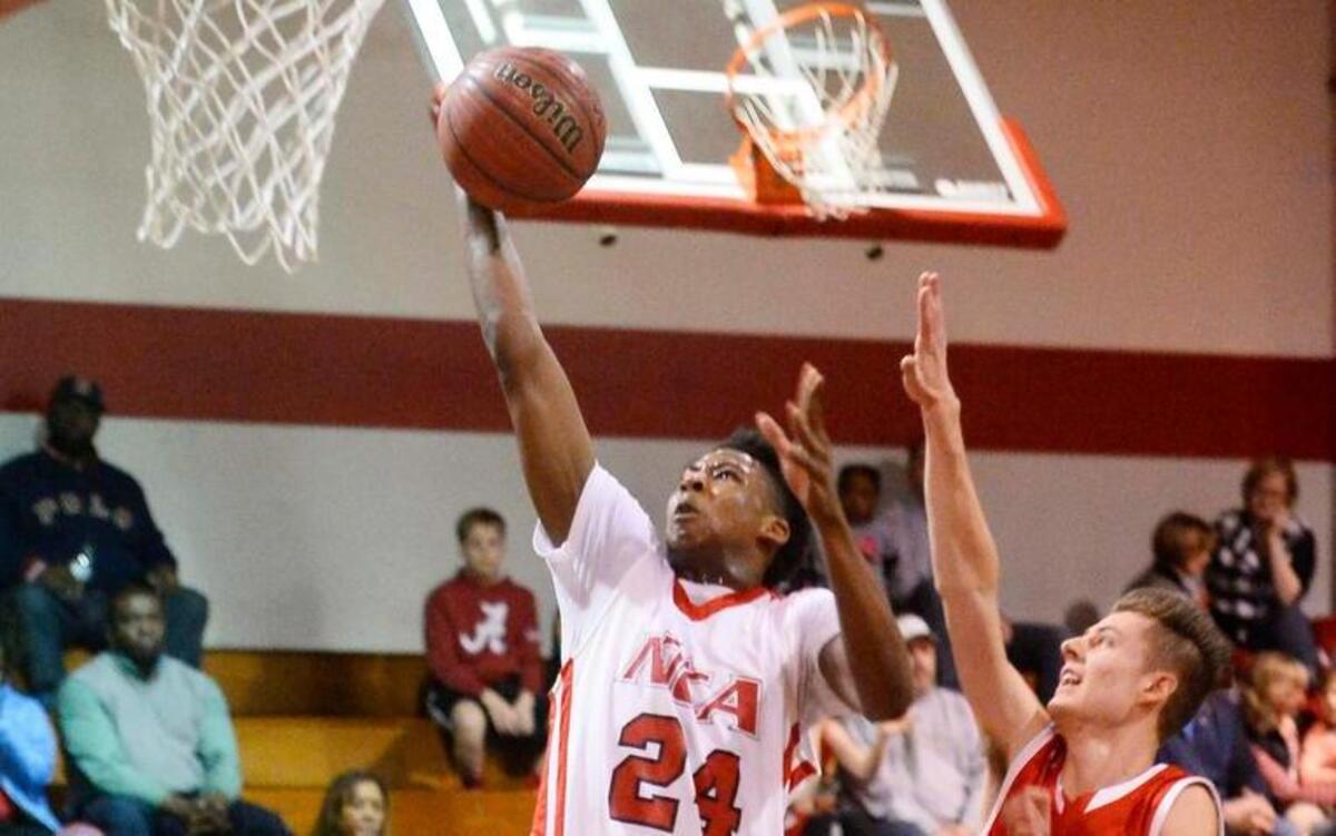 Northside Christian Academy's Nate Hinton on left, carries the ball to the basket against Gaston Christian's Tucker Knouse, on right.