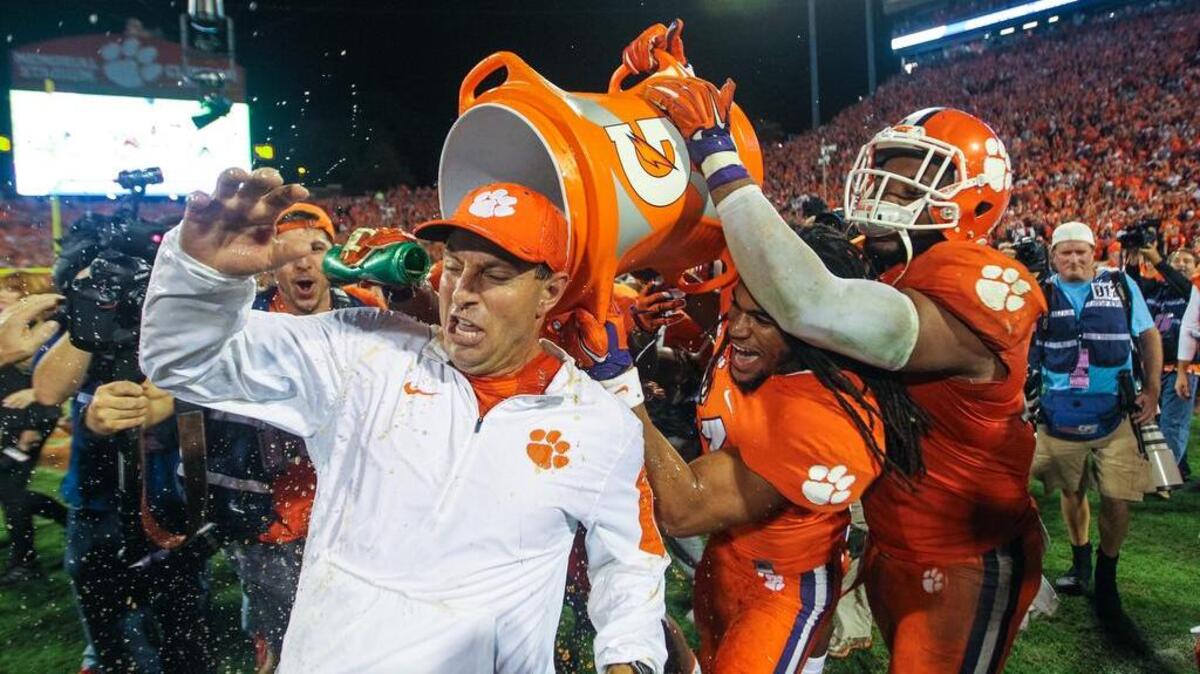 Clemson head coach Dabo Swinney gets a Gatorade bath from Clemson's running back Zac Brooks (24) and Clemson's defensive end Kevin Dodd (98) after winning their division in the ACC by beating Florida State Saturday at Death Valley.
