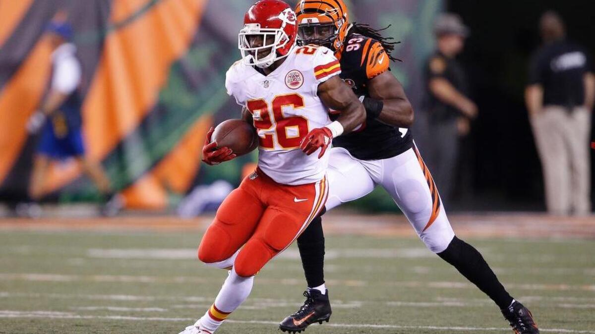 Kansas City Chiefs running back C.J. Spiller (26) runs the ball with Cincinnati Bengals defensive end Will Clarke (93) in pursuit in the second half of an NFL preseason football game in August.