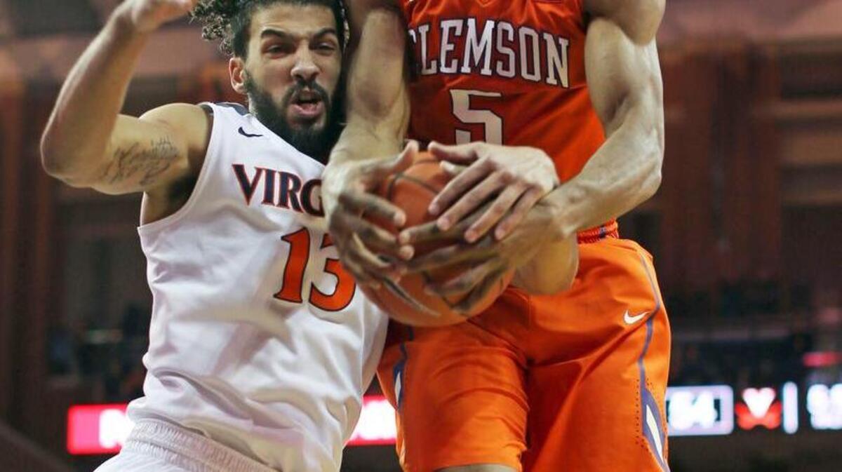 Virginia’s Anthony Gill (13) and Clemson’s Jaron Blossomgame fight for a rebound. Blossomgame had a game-high 23 points in the loss.