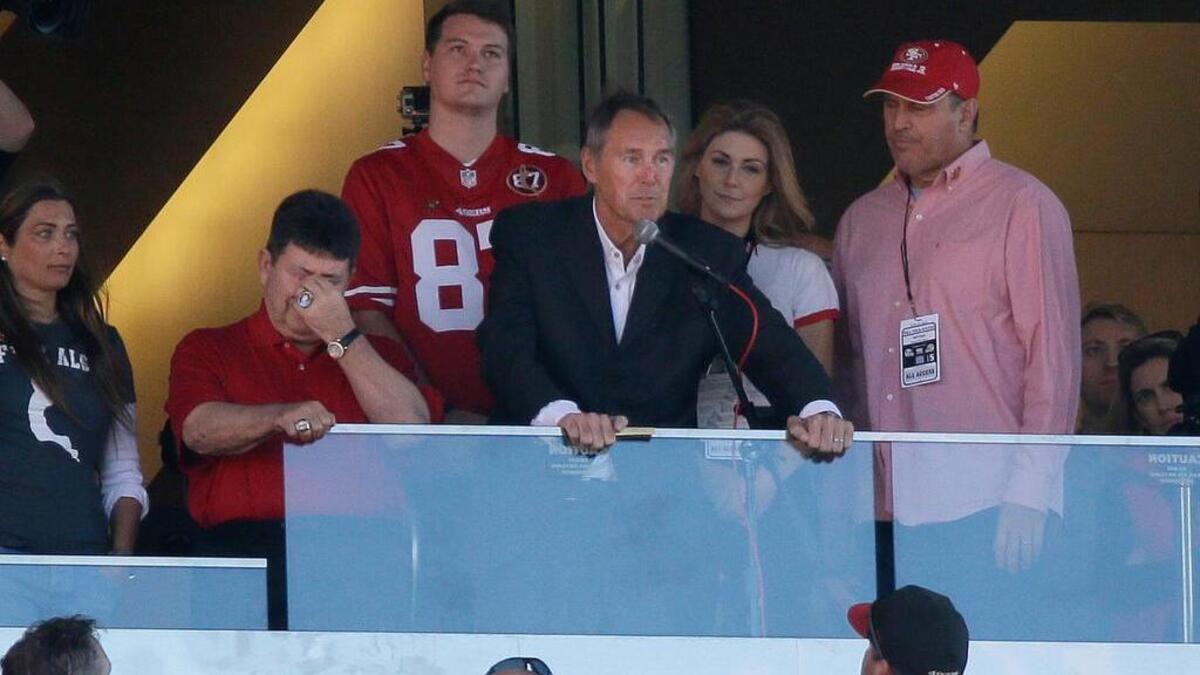Former Clemson and San Francisco 49ers wide receiver Dwight Clark, center, is cheered during halftime of an NFL football game between the 49ers and the Dallas Cowboys in October. Clark has ALS.