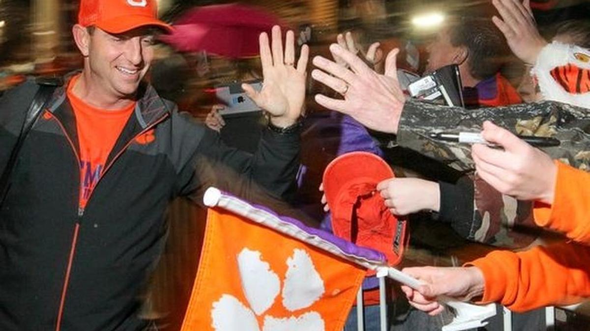 Clemson football coach Dabo Swinney greets fans after returning from Arizona at Memorial Stadium on Sunday.