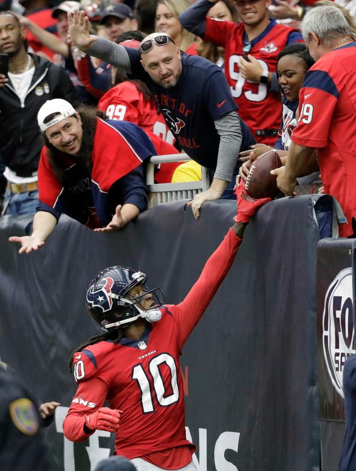 Houston Texans wide receiver DeAndre Hopkins (10) hands the ball to a fan after making a touchdown catch against the San Francisco 49ers during the second half of an NFL football game Sunday, Dec. 10, 2017, in Houston.
