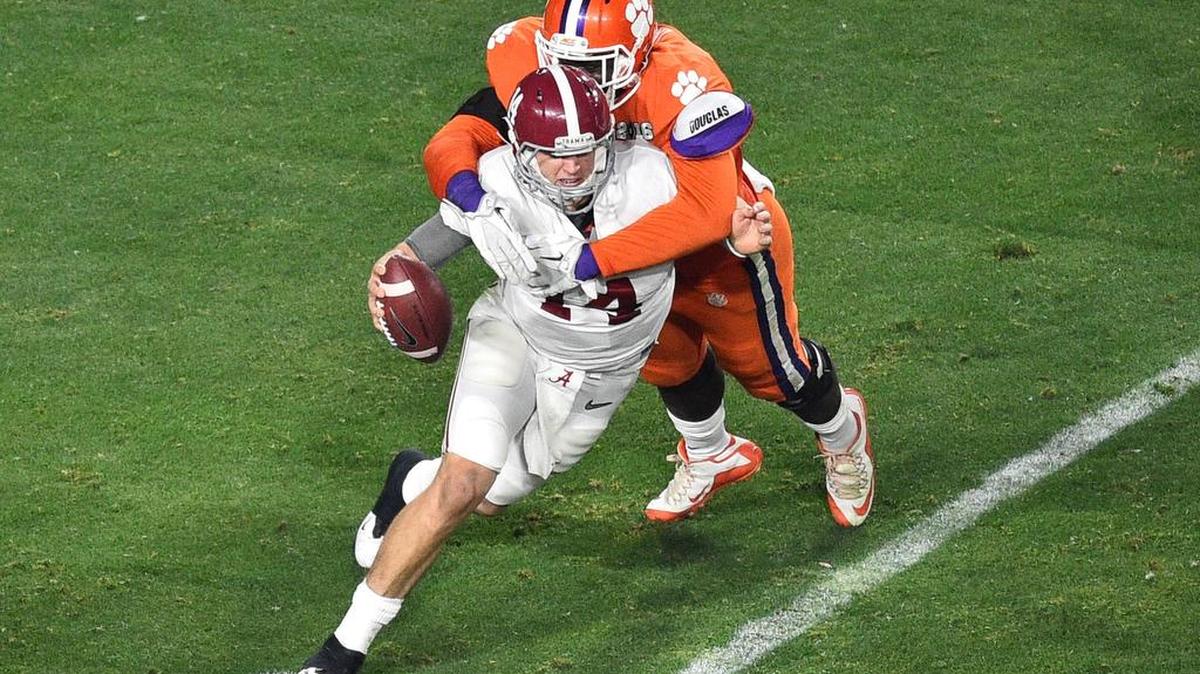 Alabama Crimson Tide quarterback Jake Coker (14) is brought down by Clemson Tigers defensive end Shaq Lawson (90)