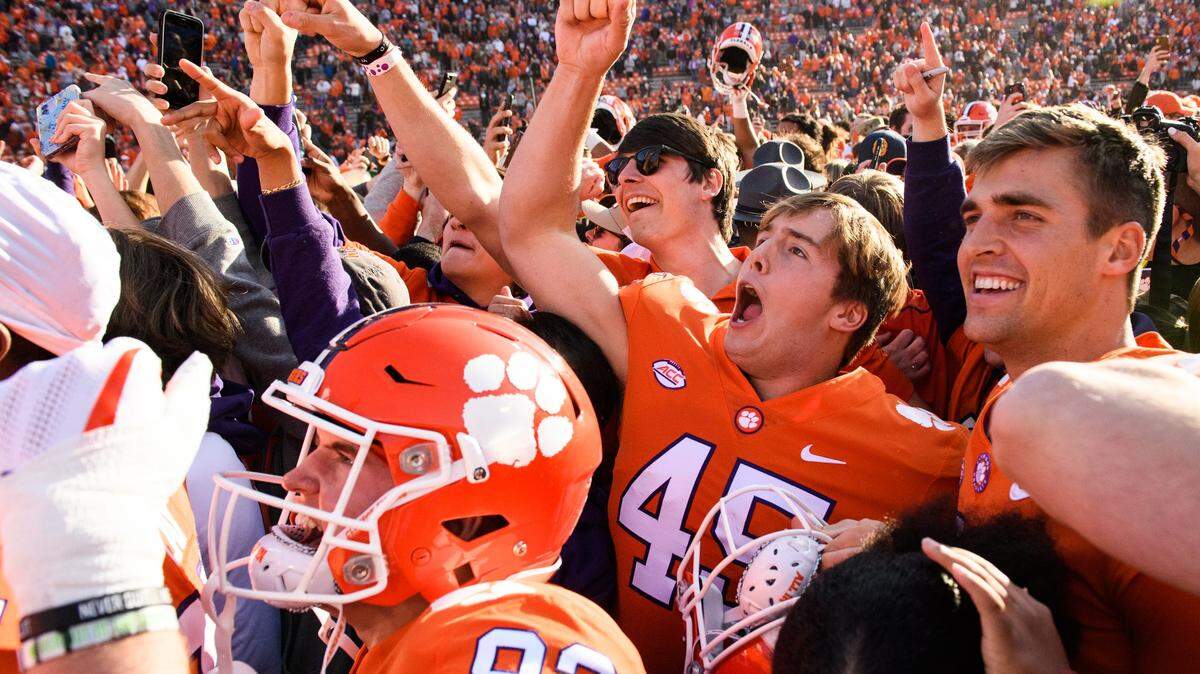 Clemson long snapper Philip Florenzo (45) celebrates with teammates and fans on the field after a 2021 win against Wake Forest at Memorial Stadium