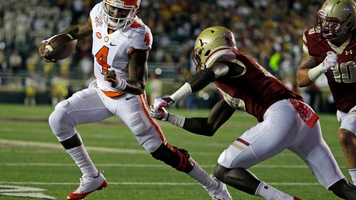 Clemson quarterback Deshaun Watson (4) dashes around Boston College defensive back Isaac Yiadom (20) and linebacker Ty Schwab (10) during their college football game Friday, Oct. 7, 2016, in Boston.