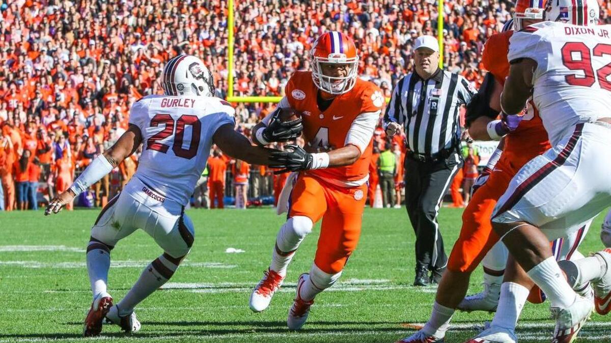 Clemson quarterback Deshaun Watson (4) shakes off the tackle of South Carolina safety T.J. Gurley (20) during the first half of the South Carolina-Clemson football game in Memorial Stadium, Saturday.