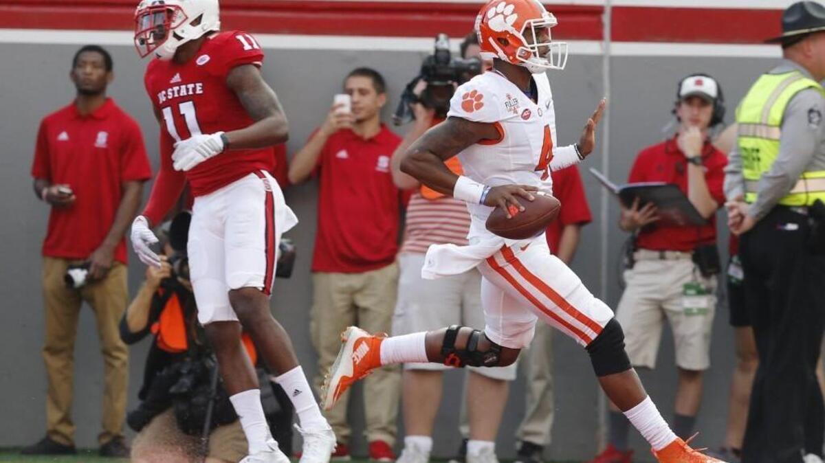 Clemson quarterback Deshaun Watson (4) runs past N.C. State’s Juston Burris (11) to score on a 24-yard rushing touchdown during the first half at Carter-Finley Stadium.