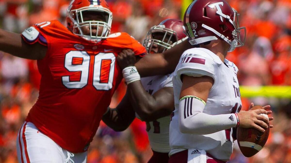 Tigers defensive tackle Dexter Lawrence attempts to tackle Troy QB Kaleb Barker.