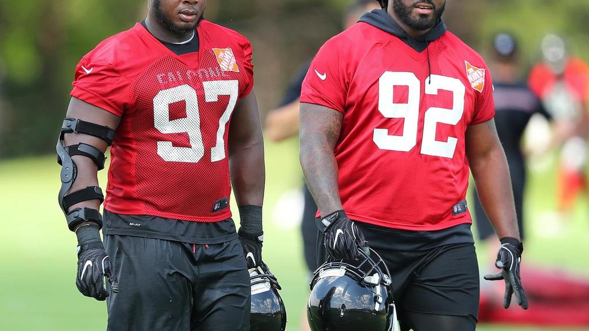 Atlanta Falcons defensive tackles Dontari Poe (92) and Grady Jarrett walk off the field after practice Tuesday.