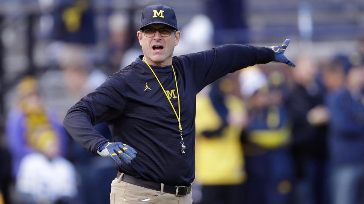 Michigan head coach Jim Harbaugh gestures to his team during warmups before an NCAA college football game against Ohio State in November.
