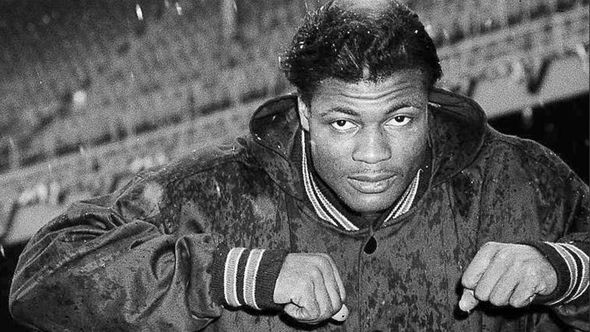 In this Dec. 29, 1956, file photo, Chicago Bears' J.C. Caroline runs through falling snow after the weather cancelled NFL football practice at Yankee Stadium in New York. Caroline, a star University of Illinois running back in the 1950s who played for the Chicago Bears for a decade, died Friday. He was 84. (AP Photo/John Lindsay, File)