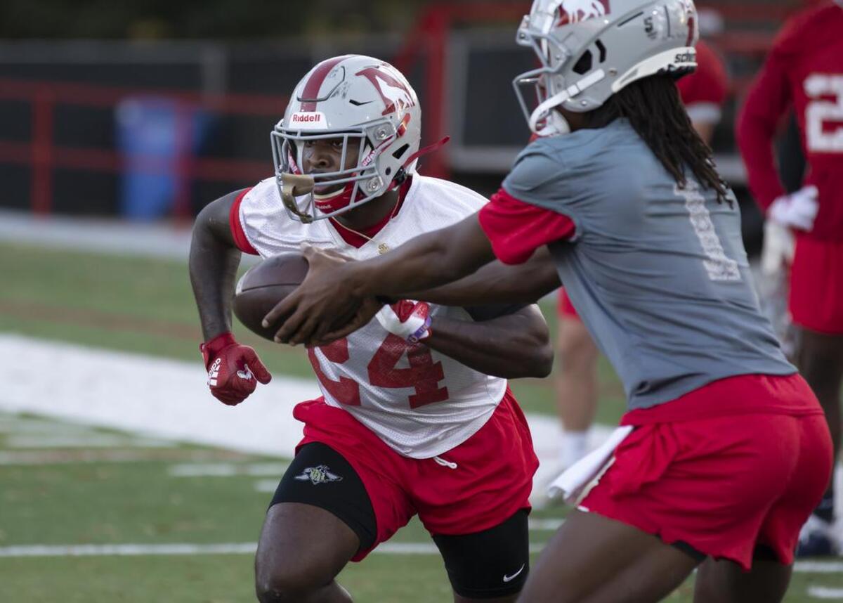 Dre Harris (right) hands off the ball to Mario Anderson during practice at Setzler Field at Newberry College on Tuesday, November 16, 2021.