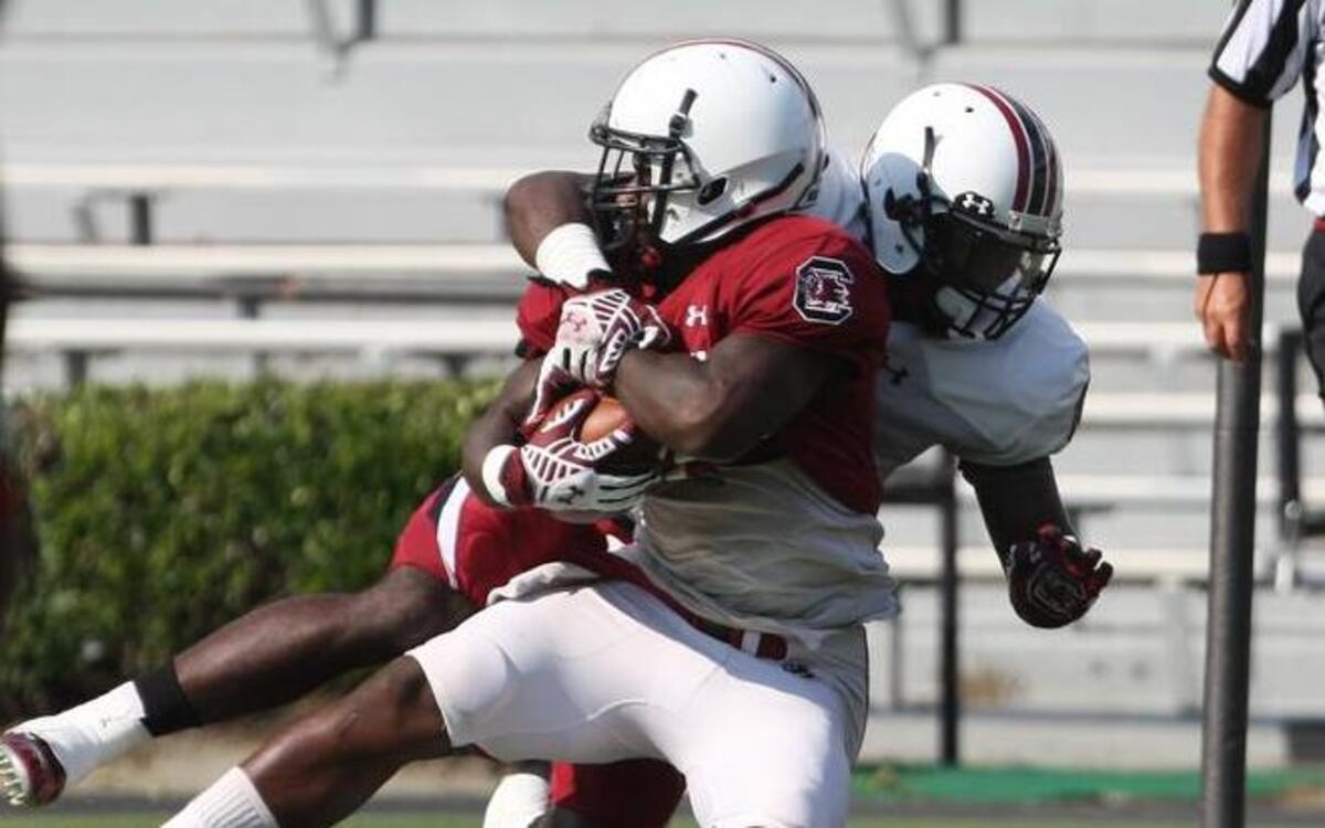 
USC tailback Shon Carson is tackled by linebacker Skai Moore during Saturday's scrimmage at Williams-Brice Stadium.
