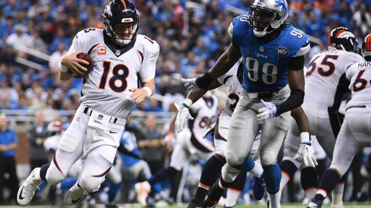 
Denver Broncos quarterback Peyton Manning (18) carries the ball while being pressured by Detroit Lions defensive end Devin Taylor (98) on Sunday.
