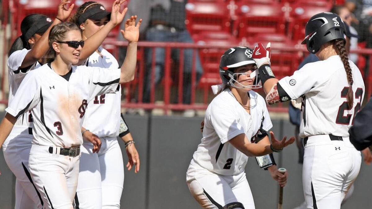 Teammates congratulate South Carolina outfielder Alaynie Page (22) after her game-ending two-RBI hit in the fifth-inning against North Carolina.