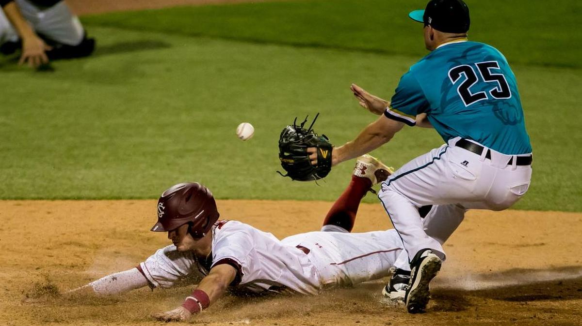 South Carolina’s Marcus Mooney scores on a wild pitch as Coastal Carolina’s Mike Morrison takes the late throw back in early April.