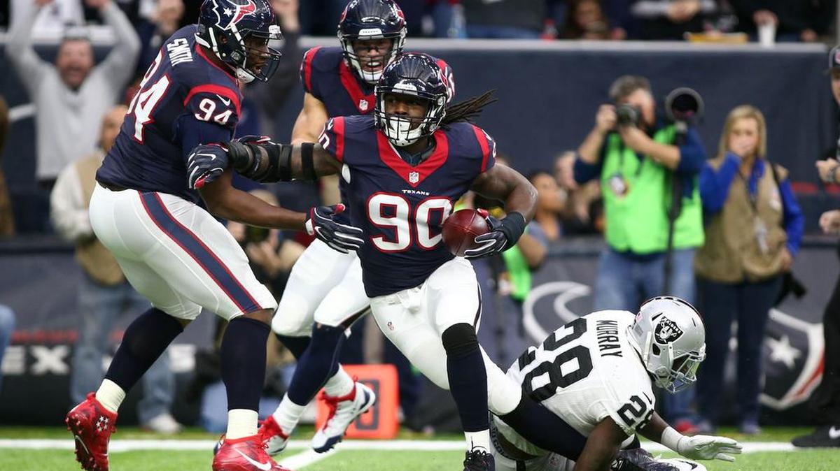 Houston Texans defensive end Jadeveon Clowney (90) is tackled by Oakland Raiders running back Latavius Murray (28) after an interception Saturday.