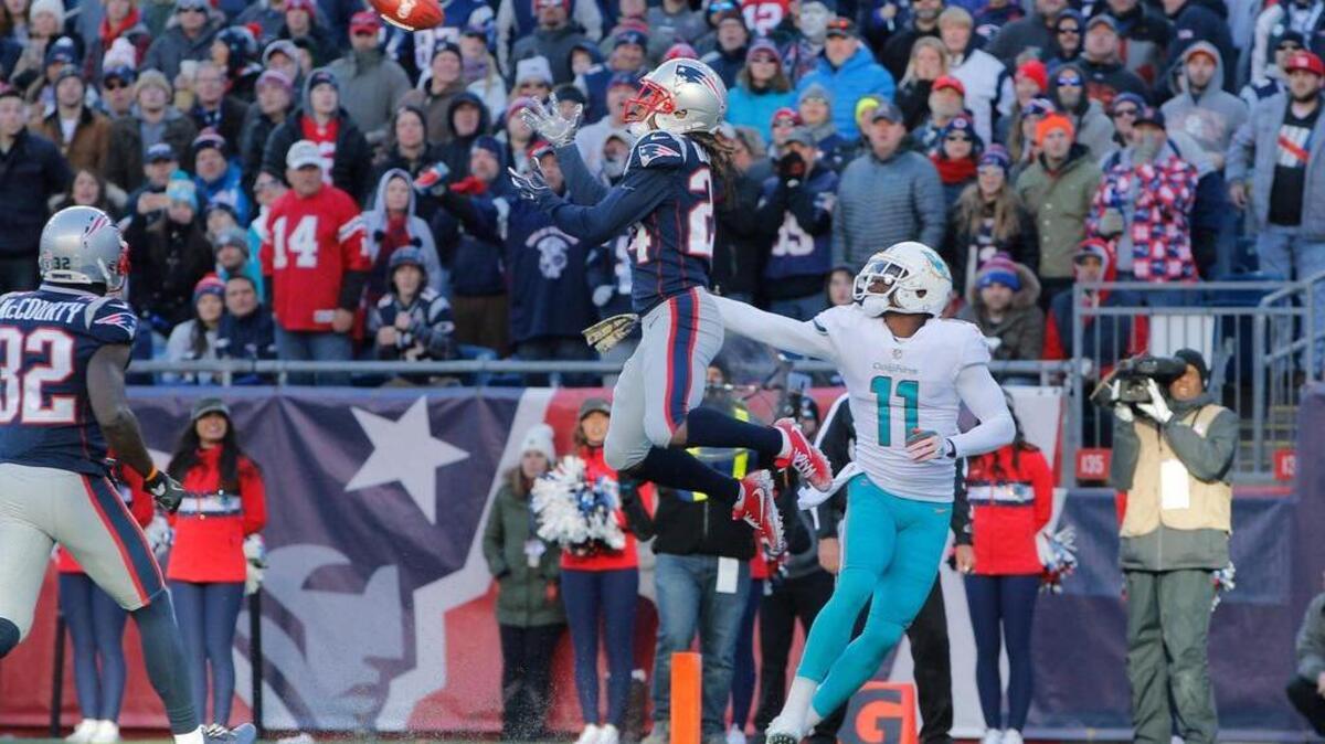 New England Patriots cornerback Stephon Gilmore (24) intercepts a pass intended for Miami Dolphins wide receiver DeVante Parker (11) in the second quarter at Gillette Stadium.