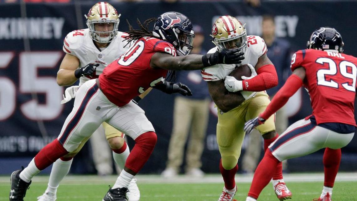 San Francisco 49ers running back Carlos Hyde (28) is grabbed by Houston Texans outside linebacker Jadeveon Clowney (90) during the first half of an NFL football game, Sunday, Dec. 10, 2017, in Houston.