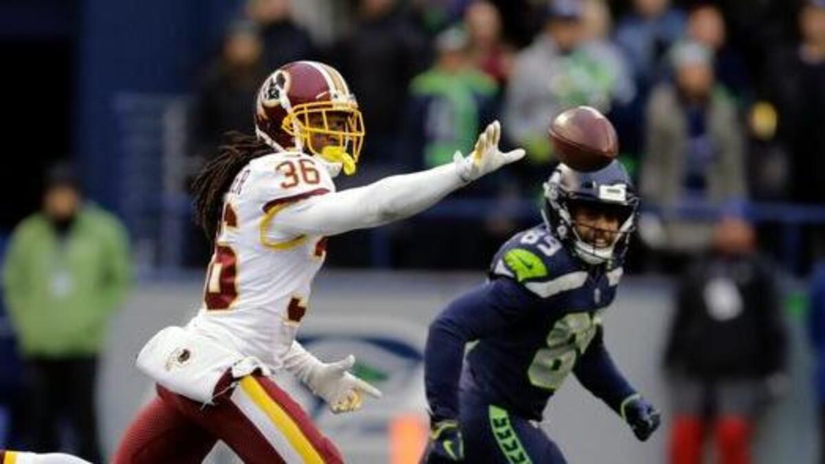 Washington Redskins free safety D.J. Swearinger, left, throws to cornerback Josh Norman, right, as Seattle Seahawks' wide receiver Doug Baldwin, center, looks on in the second half of an NFL football game, Sunday, Nov. 5, 2017, in Seattle. Swearinger was running with the ball after intercepting it on a 2-point conversion-try by the Seahawks.
