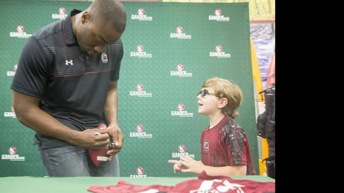 
Braxton Richardson, 5 years old of Myrtle Beach, is such a fan of Marcus Lattimore that he named his puppy “Marcus.” Richardson and other fans waited in line for up to an hour Saturday to get Lattimore’s autograph at the Grand Opening of Gander Mountain in Carolina Forest.
