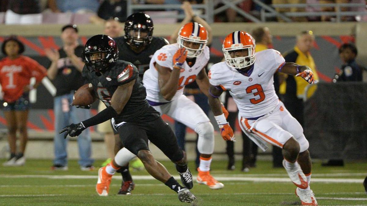 Louisville Cardinals cornerback Shaq Wiggins (6) runs back an interception against Clemson Tigers wide receiver Artavis Scott (3)