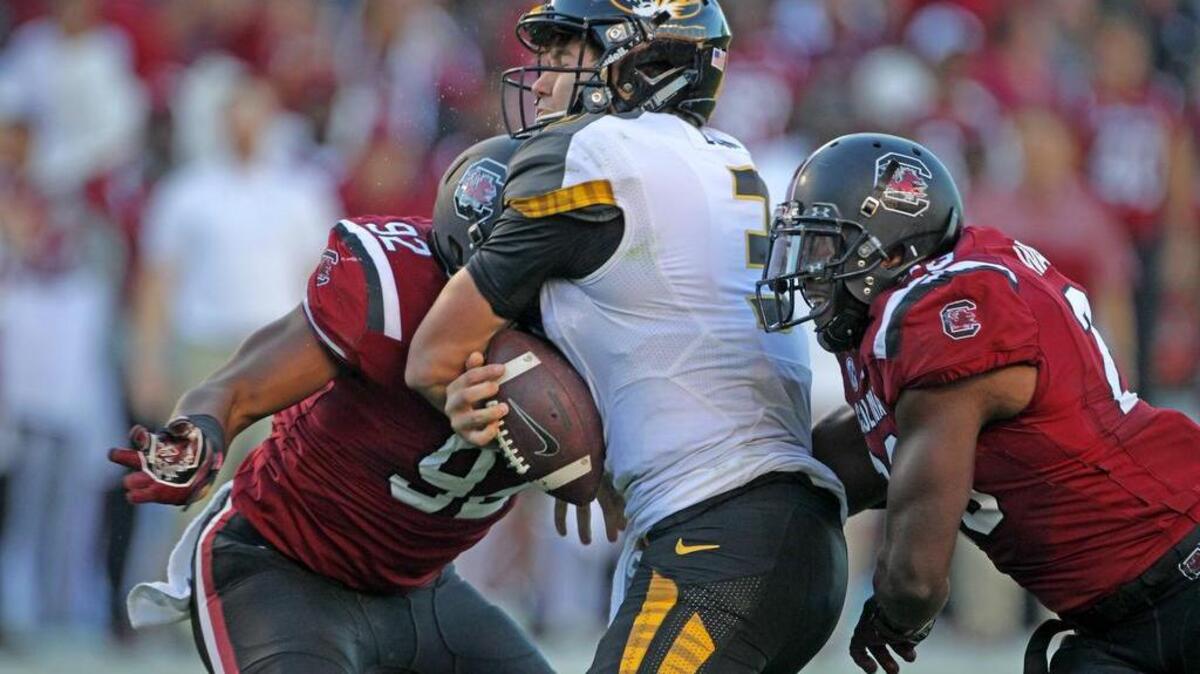 South Carolina Gamecocks defensive lineman D.J. Wonnum (92) and linebacker Jonathan Walton (28) deliver hits on Missouri Tigers quarterback Drew Lock (3)