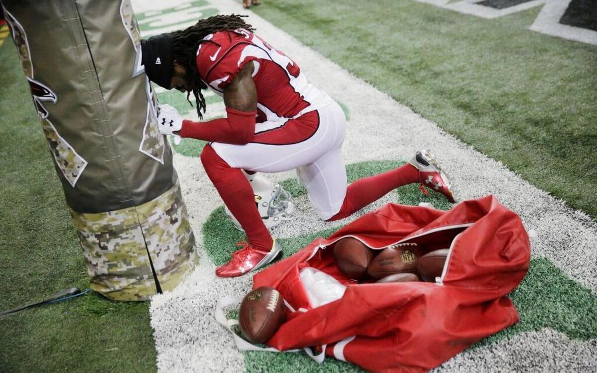 Arizona free safety D.J. Swearinger prays before the Cardinals played the Falcons.