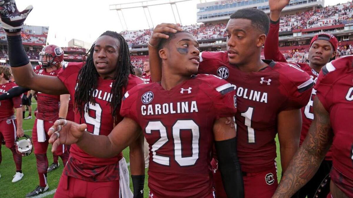 South Carolina Gamecocks wide receiver Carlton Heard (9), safety T.J. Gurley (20) and linebacker T.J. Holloman (11) gather for the alma mater after their loss to Clemson at Williams-Brice Stadium.