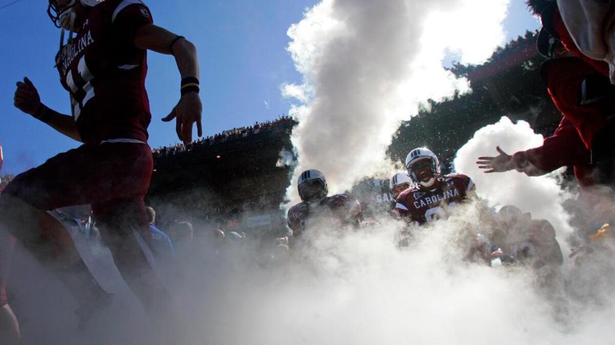 
South Carolina players run through smoke during their traditional “2001” entrance.
